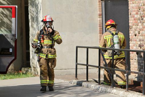 Fire fighters walk out of the Hill Center at Ithaca College after a carbon monoxide alarm went off early Friday morning.