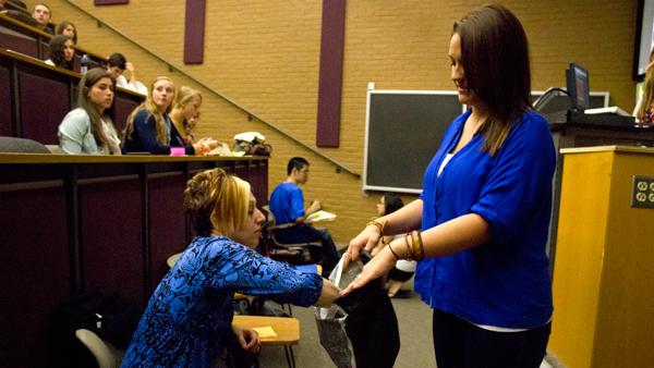 To Write Love on Her Arms adviser Alyssa Cooper grabs an anonymous inspirational message written by other students who came to discuss the issues that TWLOHA deals with, such as suicide prevention. 
