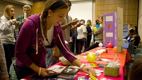Freshman Marisa Nizzi peruses the display of safe sex items and flyers Monday at the annual Sexfest in Emerson Suites. 