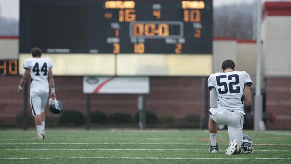 Junior linebacker Jake Santora kneels after SUNY-Cortland seals the 54th annual Cortaca Jug football game.
