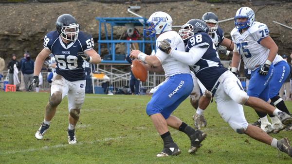 From left, junior linebacker Josh Duggan squares his shoulders to tackle Hartwick sophomore quarterback Andrew Bashford while Ithaca senior defensive end Skyler Schlenker drags Bashford down from behind during the Bombers 28-7 win Saturday.