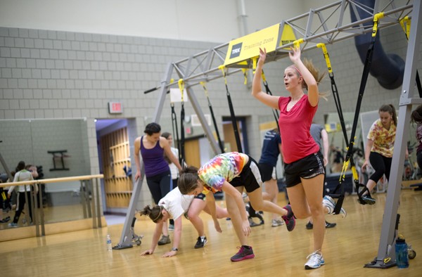 Sophomore Katie Deitz, right, performs an exercise designed to train the leg and abdominal muscles and increase aerobic endurance during a TRX class Nov. 29 in the Fitness Center.