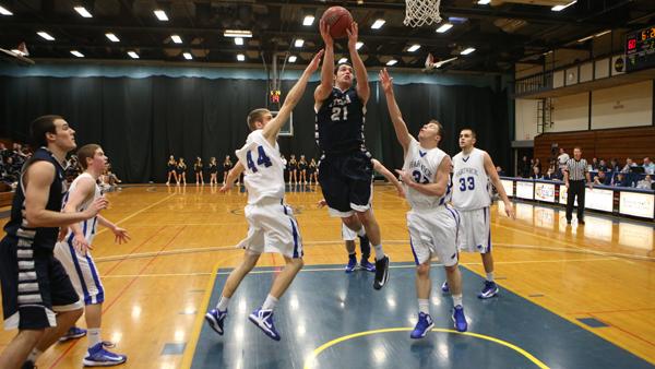 From left, Hartwick senior Aaron Laing and junior Victor Angeline attempt to block Ithaca senior Travis Warech from scoring Saturday afternoon in Ben Light Gymnasium. The Bombers defeated the Hawks 75-54 improving their record to 13-4, leading the Empire 8.