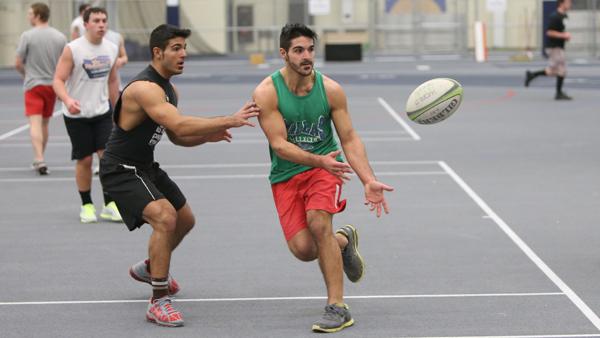 Members of the mens rugby team practice their offense in the the Athletics and Events center.