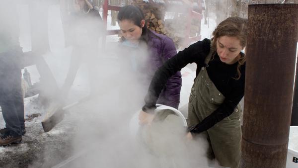 From left, freshman Menli McCreight and senior Danielle Prizzi take part in maple syrup production as part of the Natural Resources and Ecology class Sunday on Ithaca College Natural Lands. 