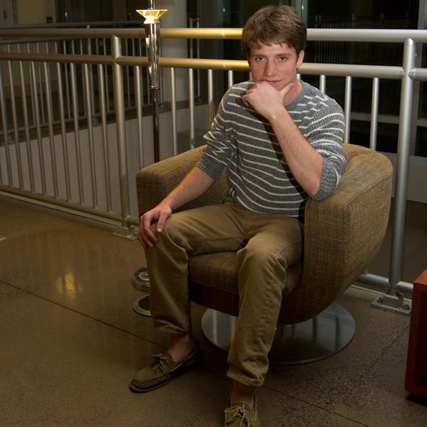 Junior Charlie Diebolt poses wearing a striped sweater and corduroy pants as part of this spring’s basic-themed trends. 