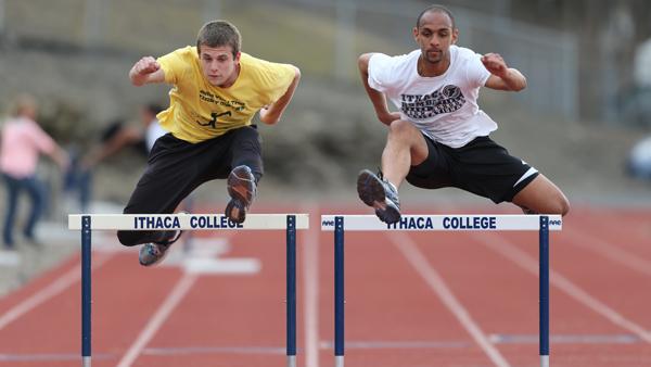 From left, senior decathletes Alec Svoboda and Rad Arrindell jump the 110-meter high hurdles during the outdoor track and field team practice Monday afternoon at Butterfield Stadium. 