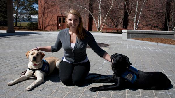 Senior Grace Goodhew snuggles with one of the guide dogs in training that is part of the Guiding Eyes for the Blind program at Ithaca College. Goodhew also practices yoga regularly and teaches courses in it downtown.