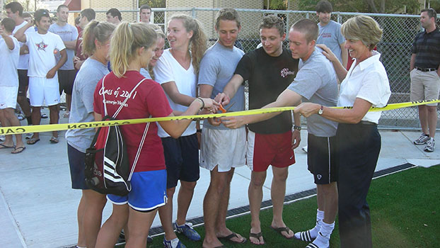 Susan Bassett (far right), director of athletics, physical education and recreation at Carnegie Mellon University, stands with student athletes of the universitys mens and womens soccer teams to cut the informal ribbon of Carnegie Mellons Intramural Soccer Field when it first opened in 2009.