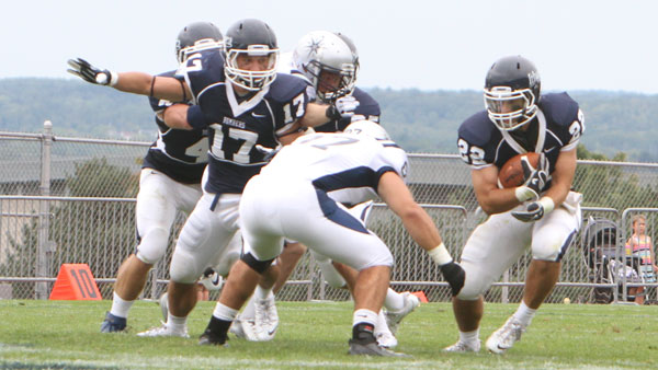 Junior corner back Sam Carney runs with the ball as senior safety Joe Armeli moves to make the tackle during the game against Moravian College on Sept. 7 at Butterfield Stadium. 