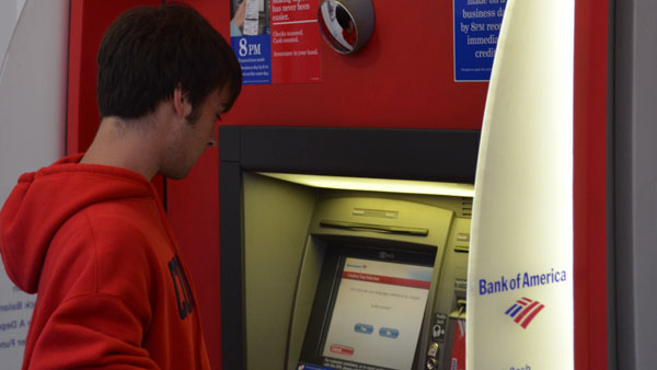 Sophomore Mathew Michaud withdraws money at the Bank of America ATM on The Commons. The branch will be taken over in November.