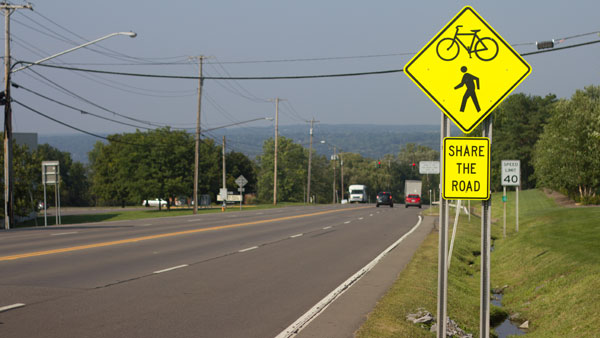 The New York Department of Travel installed Share the Road signs after Ithaca College raised concerns about the lack of sidewalk on 96B.