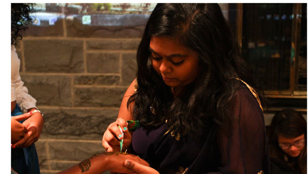 Freshman Likhita Ravuri draws Mehndi body art on community members at Around the World in 60 Minutes on Oct. 28 in Clarke Lounge.