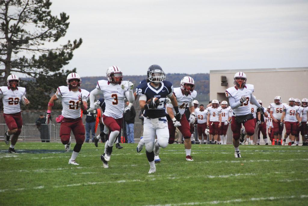 Junior Sam Carney breaks away from the defenders of a St. John Fisher College during the Empire 8 contest on Oct. 26. 