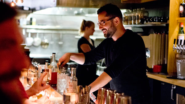 Bartender Manny Flores whips up a drink Monday night. Flores is known to maintain connections with customers.