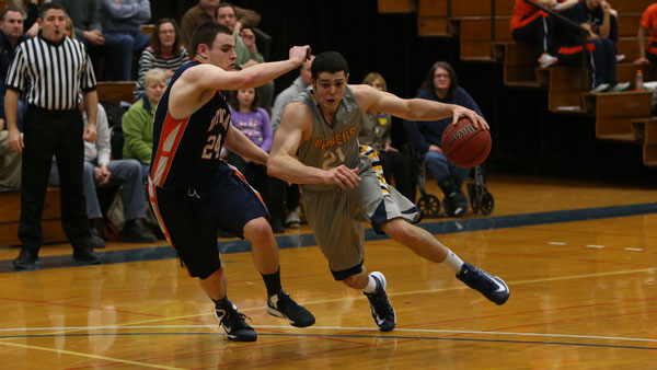 Forward Travis Warech ‘13 dribbles past Utica College senior forward Chris Jeffers during an Empire 8 conference game on Feb. 15, 2013. Warech is currently pursuing a professional basketball career in Germany.