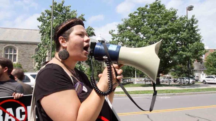 Kat Stevens, a member of Shaleshock and the Finger Lakes Action Network, speaks into a megaphone Wednesday during a protest to encourage Governor Andrew Cuomo to ban fracking in New York while he was attending a meeting in Schoellkopf Hall at Cornell University.