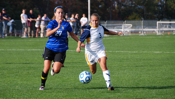 Sophomore midfielder Kelsey King dribbles the ball as a Misericordia University defender chases her. The bombers defeated the Cougars 1–0.