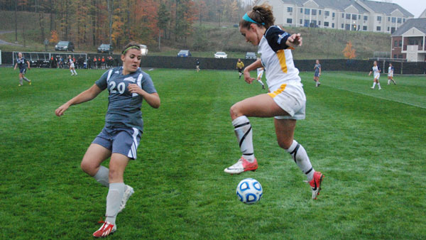 Freshman Holly Niemiec leaps in the air to save the ball during a game against Houghton College Oct. 14.