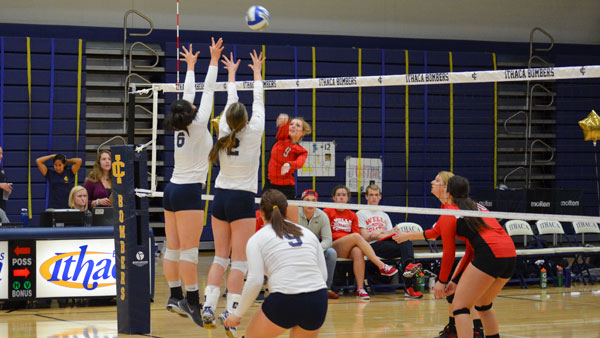 From left, freshman outside hitter Grace Chang and freshman middle Breanne Tuohy attempt to block a spike during the teams game against Wells College on Oct 29.