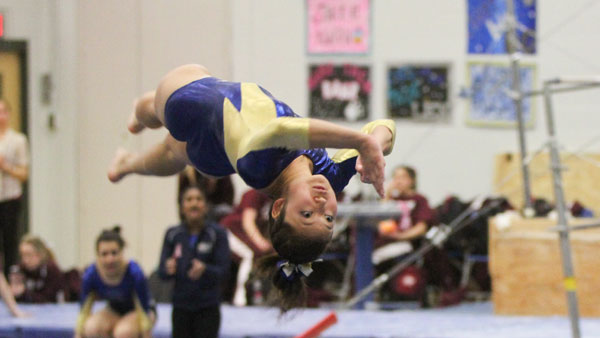 Sophomore Megan Harrington launches into a backflip during her routine at the gymnastics team’s tri-meet against Springfield College and Ursinus College on Jan. 25 in Ben Light Gymnasium. 