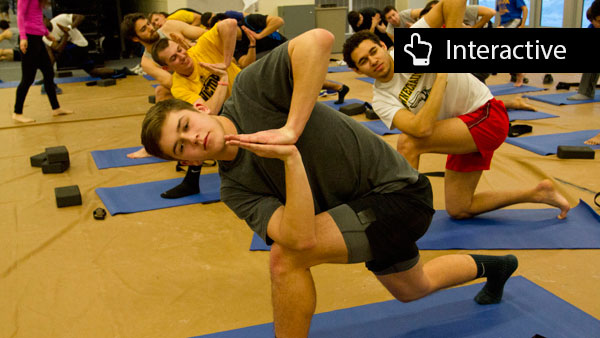Freshman sprinter Sam Piraneo holds a pose to his left side while members of the men’s track and field team join in during a weekly yoga session at practice Feb. 10 in Glazer Arena.