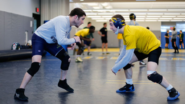 From left, junior Anthony Cabrera sizes up freshman Jimmy Kaishian during the wrestling team’s practice March 4 in the Hill Center. Kaishian is one of six Bombers competing in the NCAA Championships from March 14–15.
