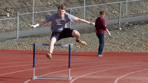 Senior hurdler Brennan Edmonds extends over a hurdle during the mens track and field teams practice April 1 at Butterfield Stadium. Edmonds has competed while wearing a cast on his right wrist for eight weeks.