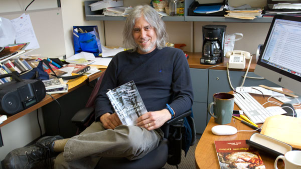 Jerry Mirskin, associate professor of writing, poses with his latest collection of poetry April 30 in his office. Mirskins latest book of poetry, titled Crepuscular Non Driveway, is his third published collection.
