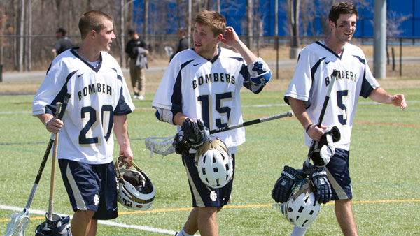 From left, senior midfielder Andrew Kristy, junior midfielder Steve Danylyshyn and junior attack James Manilla walk off the field after a 10–8 victory against Nazareth College on April 12.