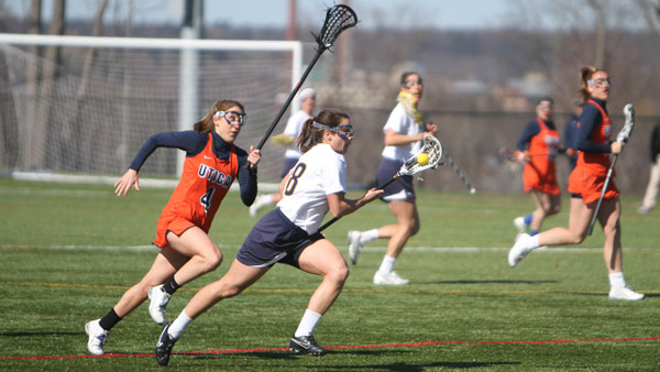From left, Utica College junior defender Patricia Kane tries to steal the ball from sophomore midfielder  Riley Marion during the Bombers’ 15–0 win against the Pioneers on April 24 at Higgins Stadium. 