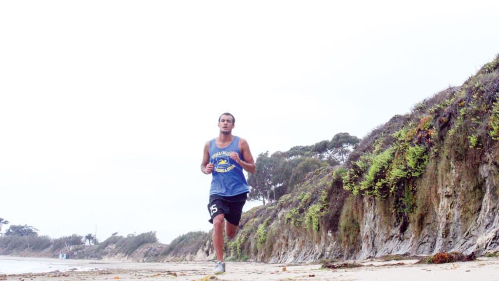 Junior swimmer Vincent Dodero jogs on the sand at Devereux Beach in Goleta, California, as part of his training regimen. 