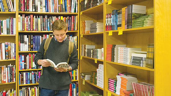Freshman Bradford Allen browses the stacks at Buffalo Street Books. Buffalo Street Books is a local co-op that offers a program called “First Class,” where students can order their books for classes instead of using the college’s store.
