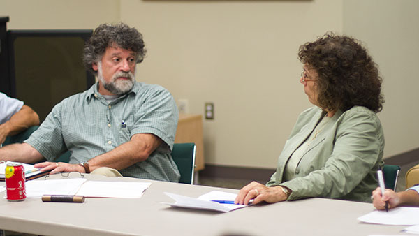 Peter Rothbart, professor of music theory, history, and composition, and Linda Petrosino, interim provost and vice president of educational affairs, gather at the Faculty Council meeting to discuss budget reforms and academic advancements