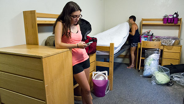 Sophomore Liza Foley stands nearby as her mother, Janese Guiliano, makes her bed on Aug. 25.