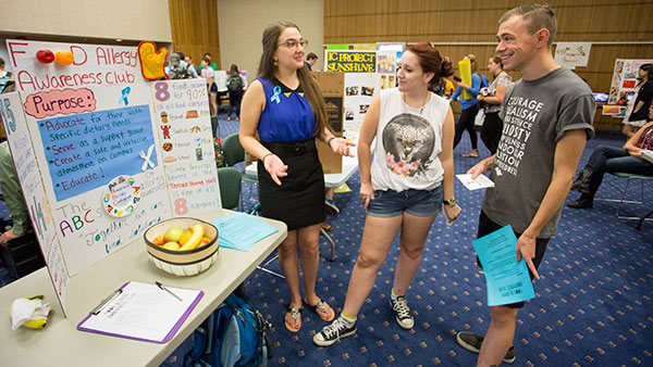 Mackenzie Gannon 17 shares information about her new club for food allergy awareness with Rachel Huley 17 and Bob Haskell 15 at the student organization fair Sept. 3.