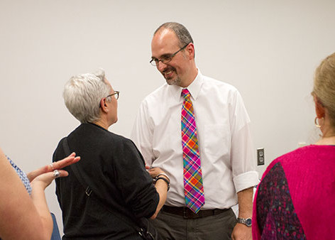 Matthew Fee, former Park Scholar program director, shakes hands with Elisabeth Nonas, associate professor of  cinema and photography, at the reception held in Fee’s honor on Aug. 28 in the Roy H. Park School of Communications.