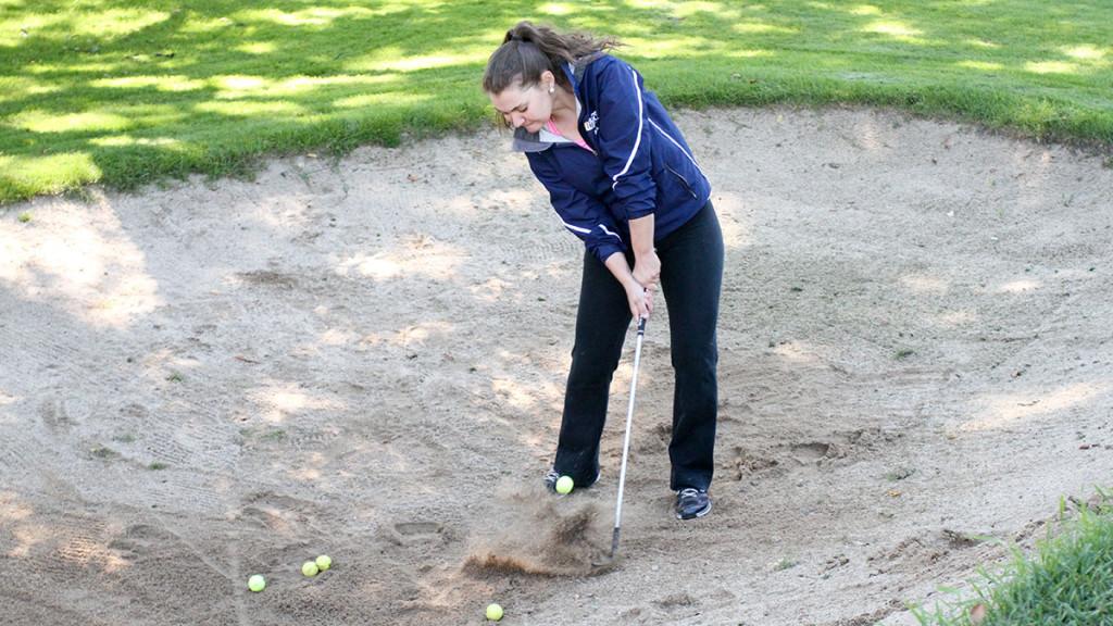 Freshman Kyra Denish hits a shot out of one of the sand bunkers during  the golf team’s practice on Sept. 19 at the Country Club of Ithaca. 