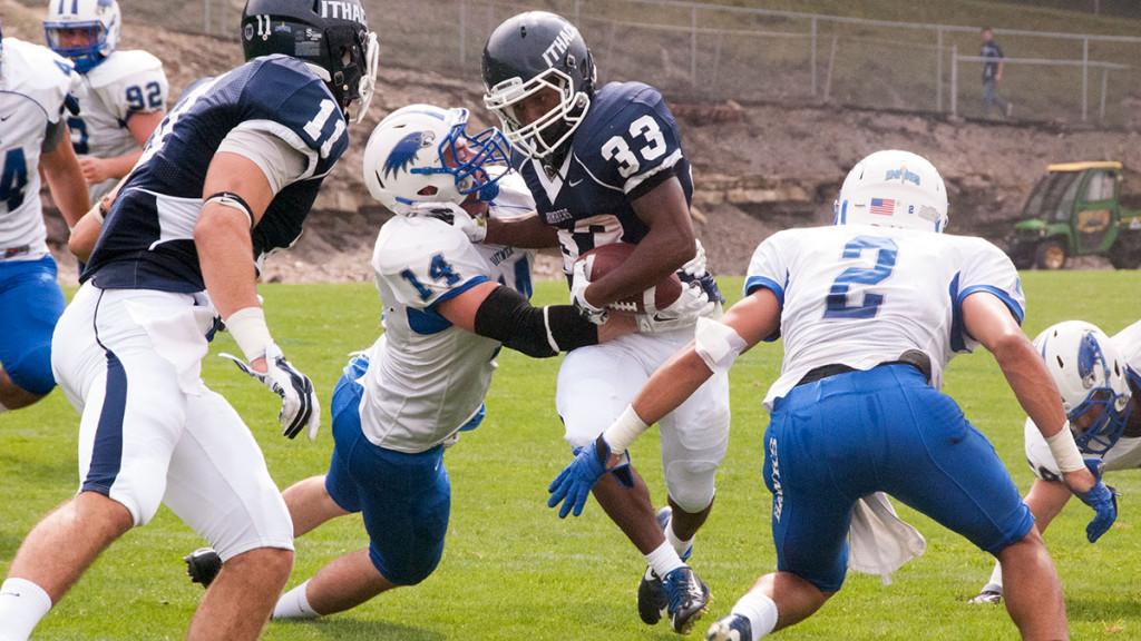 Freshman running back Tristan Brown fights through a tackle from Hartwick College senior safety Jared Morrow during the Bombers 42–7 win over the Hawks Sept. 20 at Butterfield Stadium. 