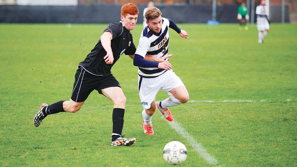 From right, sophomore forward Cobi Byrne tussles with Nazareth College junior midfielder Michael Batiste during the men’s soccer team’s 1–0 win over the Golden Flyers on Nov. 1 at Carp  Wood Field. The team will face Utica College on Nov. 7 in the Empire 8 Tournament semifinal. 