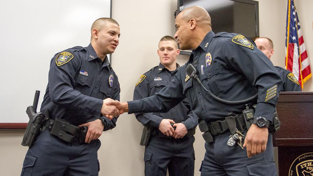 From left: newly sworn in Ithaca Police Officer Joseph Jiminez shakes hands with Deputy Chief Peter Tyler.