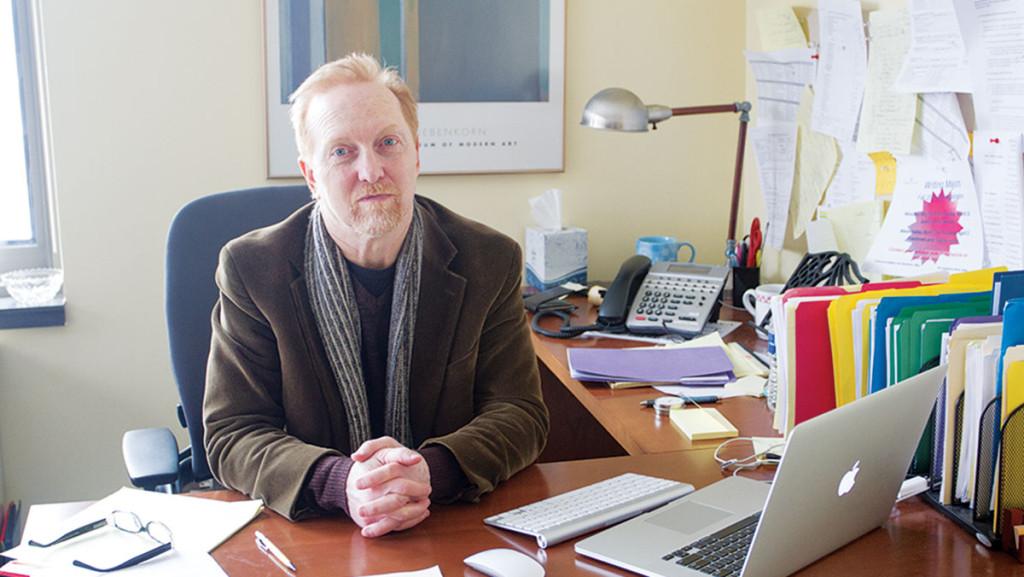 Cory Brown, associate professor of writing at Ithaca College, sits at his desk in Smiddy Hall. Brown’s essay was published in the South Loop Review.