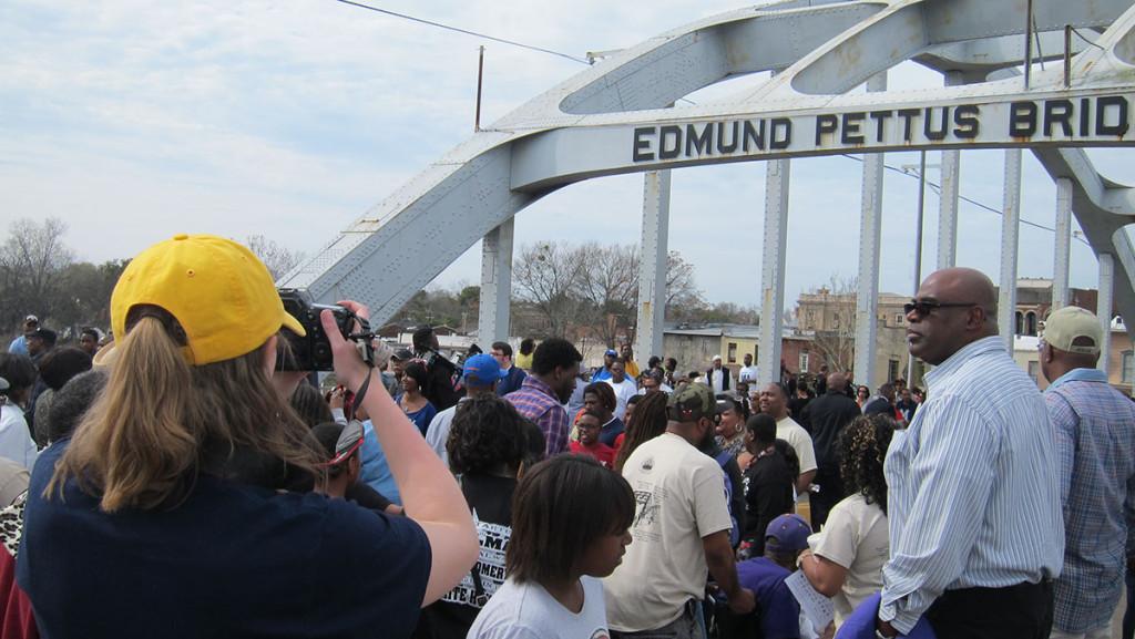 Senior Sara McCloskey captures footage of the crowd of people as they march across the Edmund Pettis Bridge on March 7 in Selma, Alabama.  
