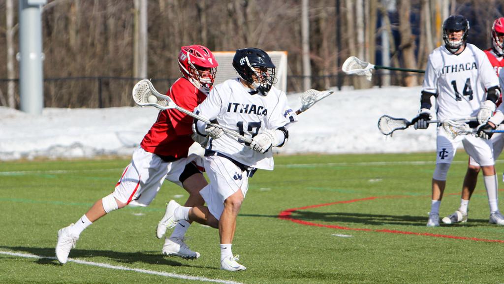 From right, senior midfielder Matt Greenblatt beats a SUNY Oneonta defender while looking for an open teammate in the men’s lacrosse team’s 9–8 win over the Red Dragons on March 17.