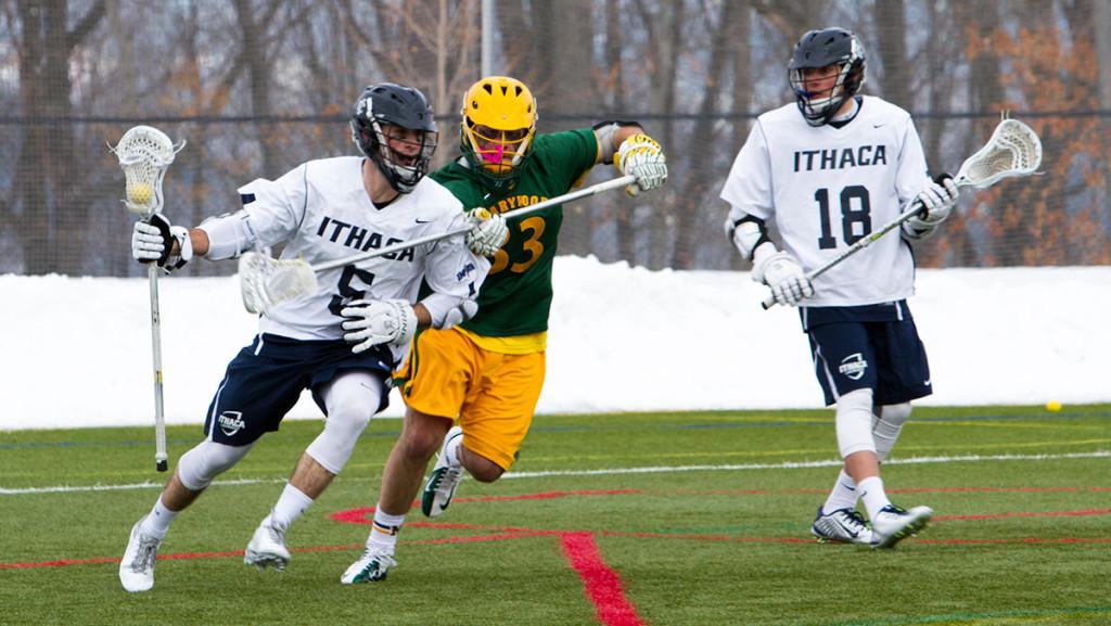 From left, senior attack Jame Manilla attempts to carry the ball past a University of Marywood defender as freshman attack Jake Cotton looks on. Manilla scored a goal as the Bombers defeated the Pacers 13–10.