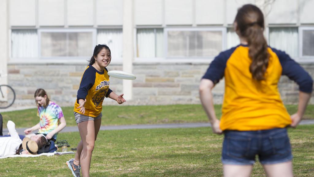 Ithaca+College+students+toss+a+frisbee+while+enjoying+the+warm+spring+weather.