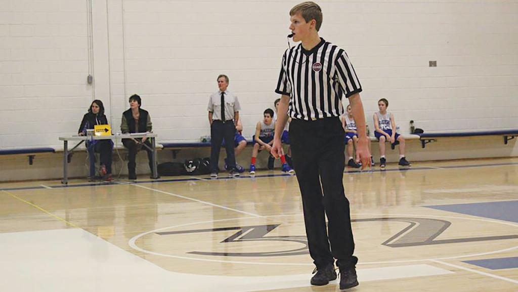 Junior Clark Stridsberg referees a middle school basketball game during winter break.