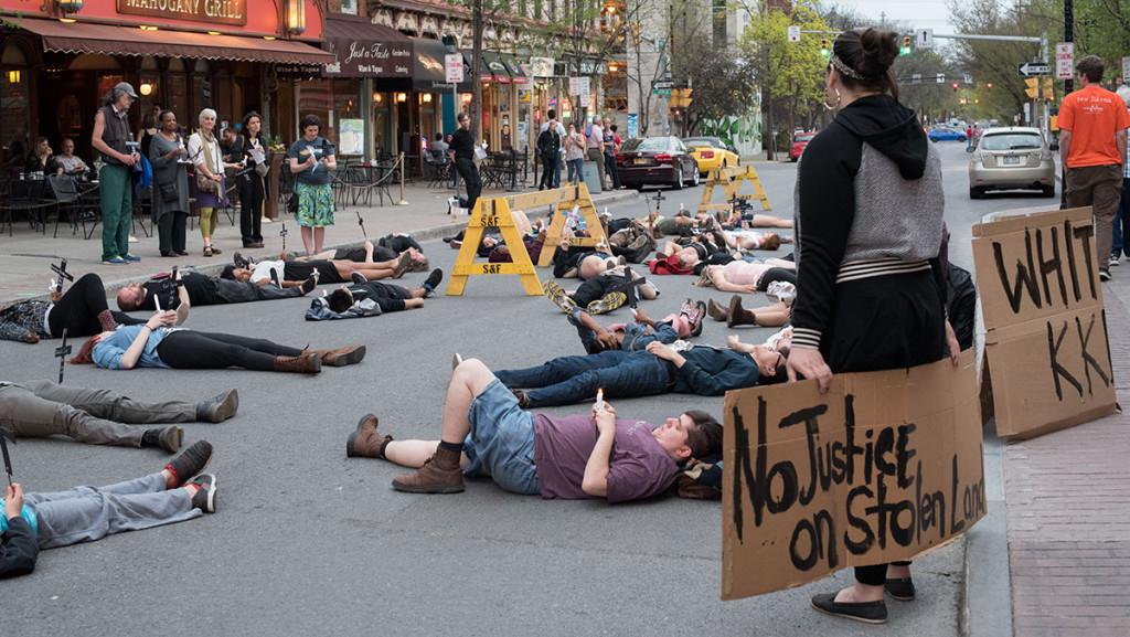 More than 50 Ithaca-area residents hold a die-in protest on South Aurora Street near The Commons.  