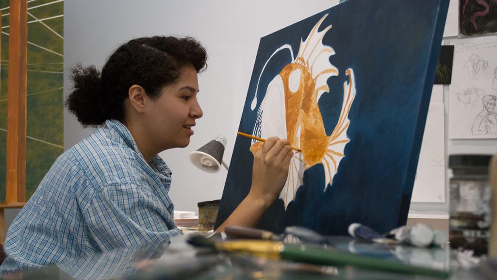 Senior Andrea Aguirre puts the finishing touches on her painting in the art departments Creative Space Gallery.