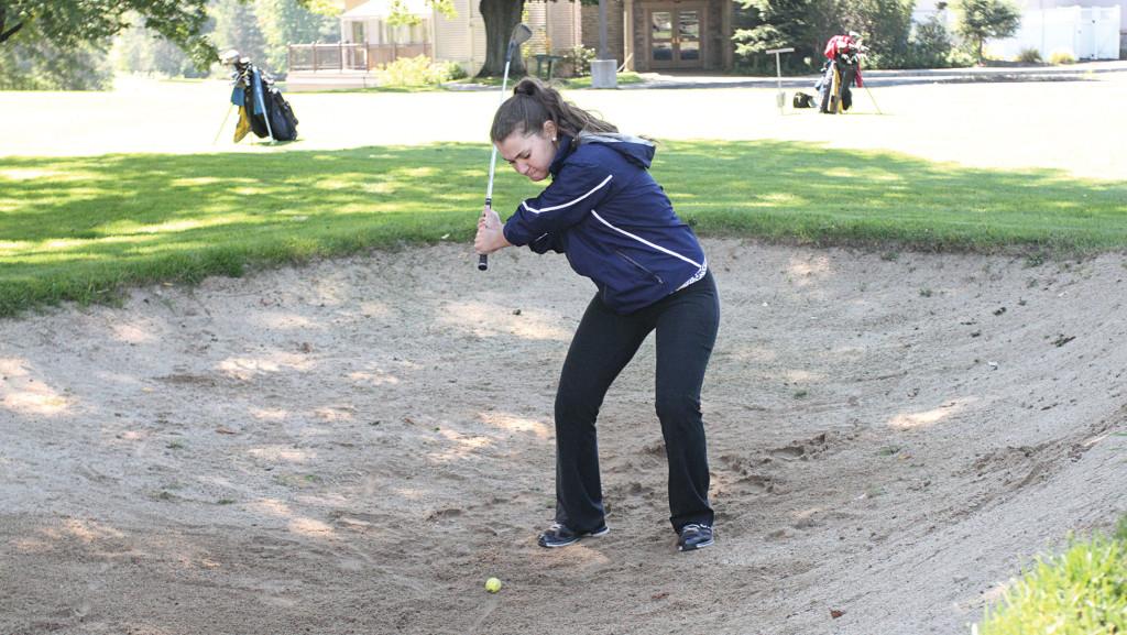 Sophomore Kyra Denish keeps her eye on the ball as she makes her backswing during a team practice Sept. 19, 2014, at the Country Club of Ithaca.